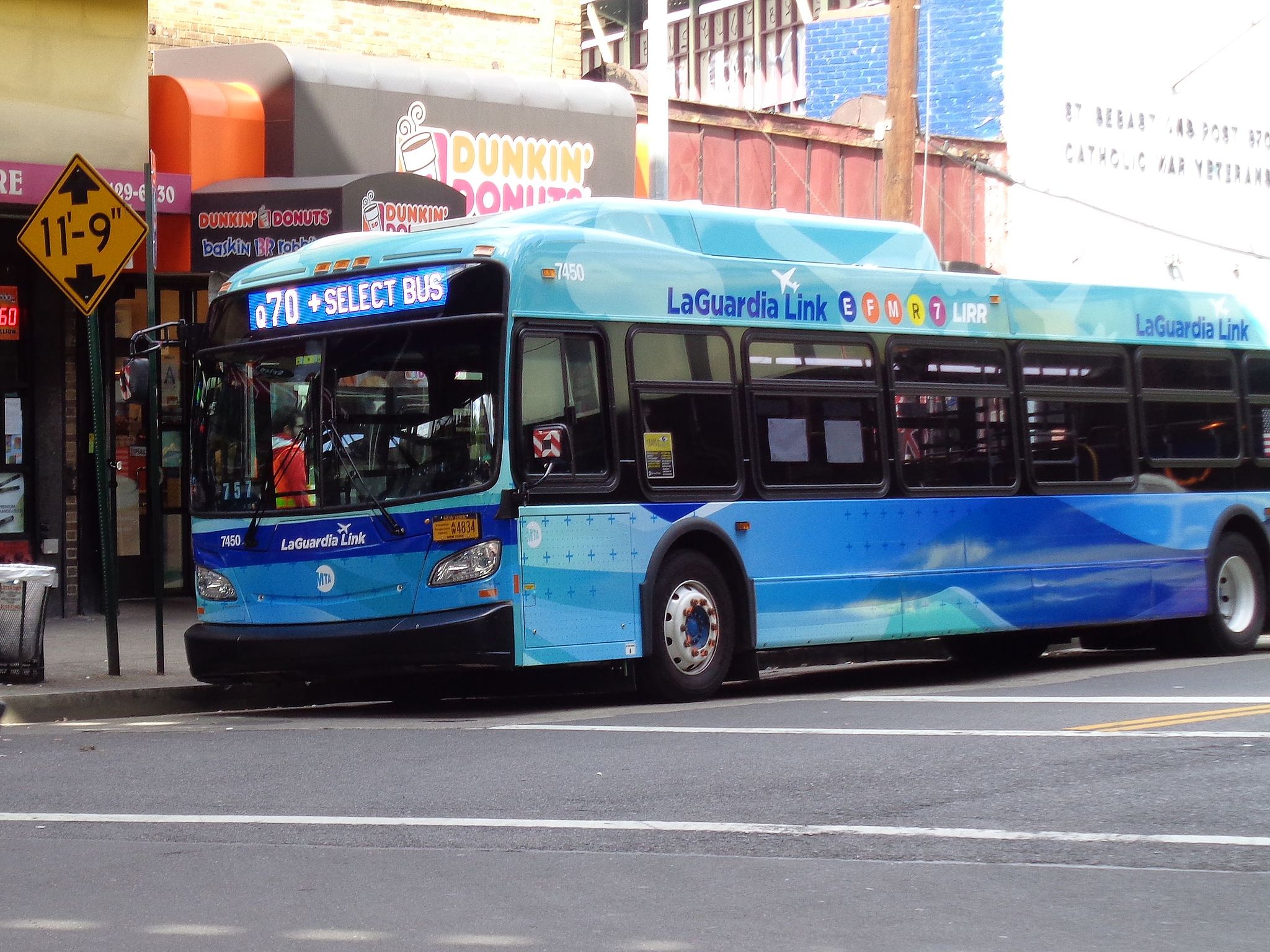 A Q70 Select Bus Service under the 61st Street–Woodside subway station in Woodside, Queens. Image by Tdorante10 (Own work) CC BY-SA 4.0, via Wikimedia Commons