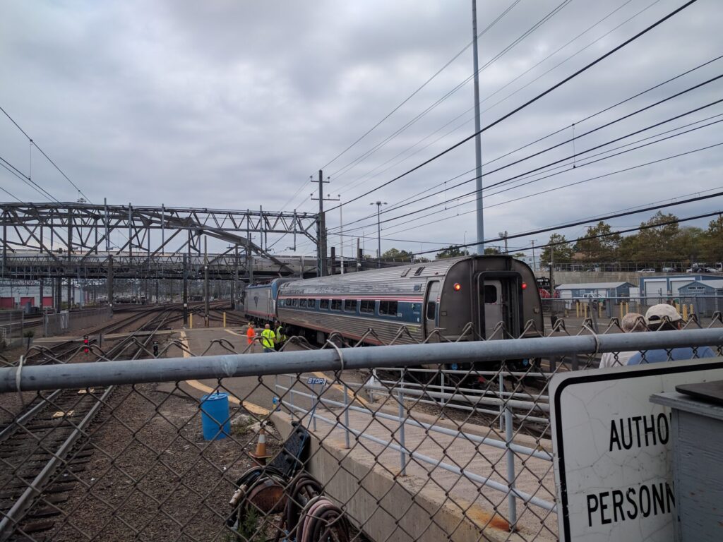 An electric locomotive with an extra coach backs in