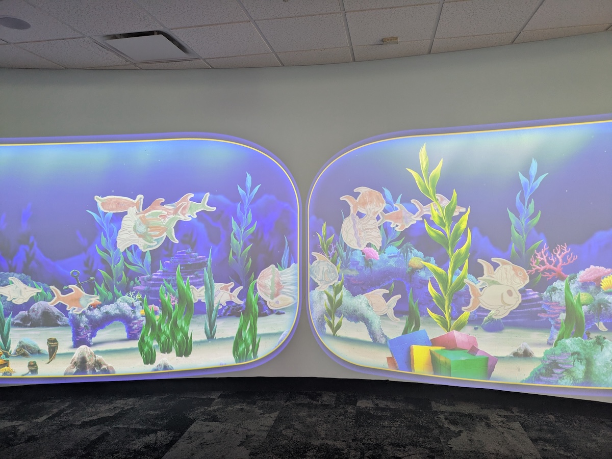 Scanned images of paper fish float on screen