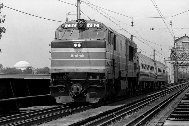 A train crosses a bridge. This image is licensed CC-BY-2.0 and was taken by Hunter Desportes.